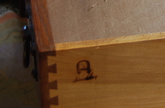Close up branded Gustav Stickley signature on side of drawer.